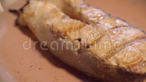 刚煮熟的多汁的香煎鱼片用酱汁浇水在木桌上摆放精美关门视频的预览图