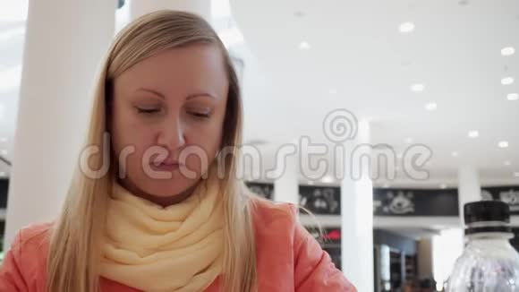 咖啡馆里有魅力的女人用塑料刀和叉子吃披萨视频的预览图