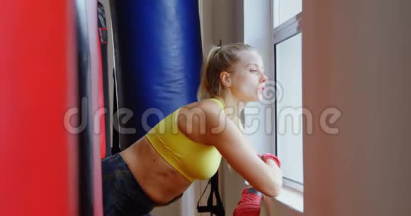 4k健身室的女拳击手透过窗户视频的预览图