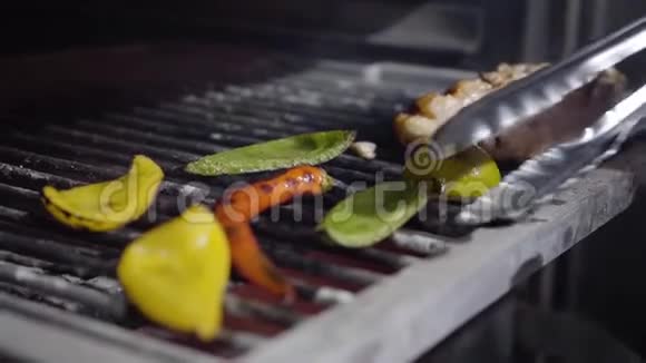 厨师手从烤架上拿蔬菜用钳子把它们放在盘子上胡椒和柠檬视频的预览图