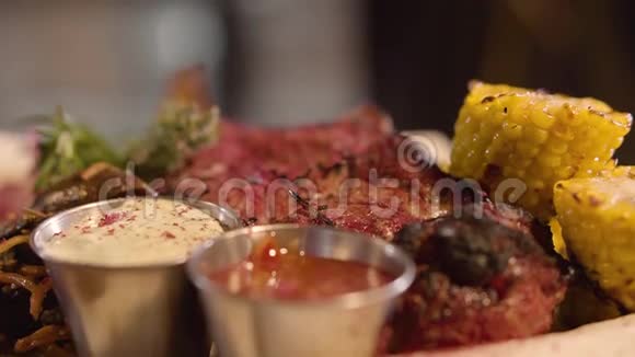 鲜嫩多汁的肉片上撒着调料凑近美味的肉放在盘子里上面有玉米酱汁和青菜视频的预览图