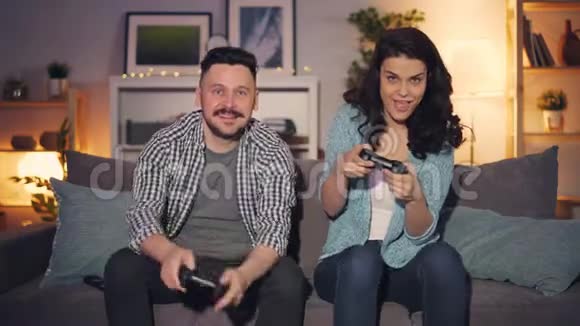 男人和女人在公寓里玩电子游戏快乐女孩赢了视频的预览图