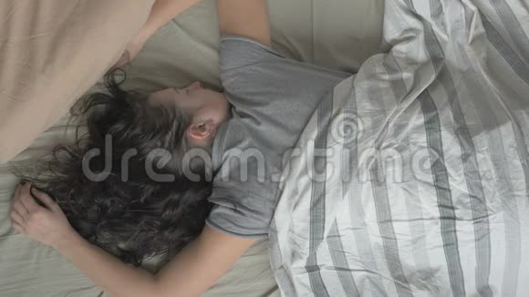 新鲜快乐的女人在床上早上醒来睁开眼睛微笑然后睡着了从视频的预览图