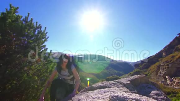 登山女孩背着背包在山顶上张开双臂视频的预览图