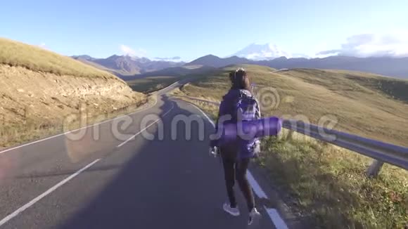 女游客背着背包在路上搭便车视频的预览图