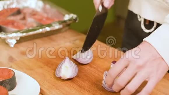 贴身女人她的手在厨房的木板上切洋葱视频的预览图