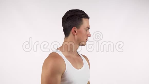 英俊的肌肉男伸展着他的六块腹肌举起他的衬衫视频的预览图