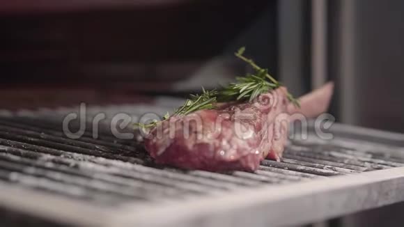 美味可口的生肉与香料和新鲜的迷迭香叶躺在烤架上准备煎慢动作视频的预览图