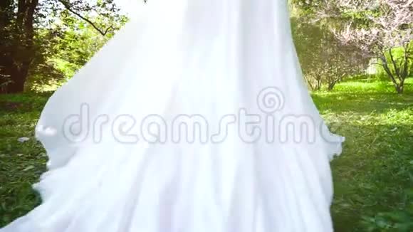 在盛开的花园里慢动作行走的新娘的追踪镜头视频的预览图