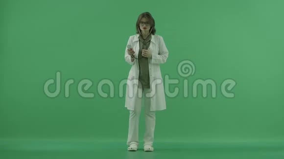 医生用听诊器听着然后把它放在她脖子上的绿色屏幕上视频的预览图