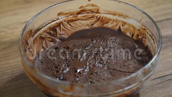 女人在碗里搅拌美味的巧克力奶油桌上有铲子视频的预览图
