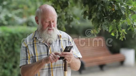公园里的老人用手机打字视频的预览图