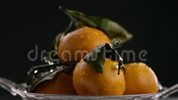 在视频中我们看到橘子它们是折叠的然后水开始从顶部落下黑色的背景视频的预览图