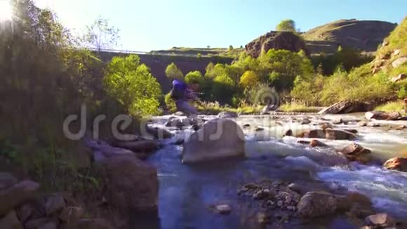 徒步旅行者背着背包在一条山河上欢乐视频的预览图