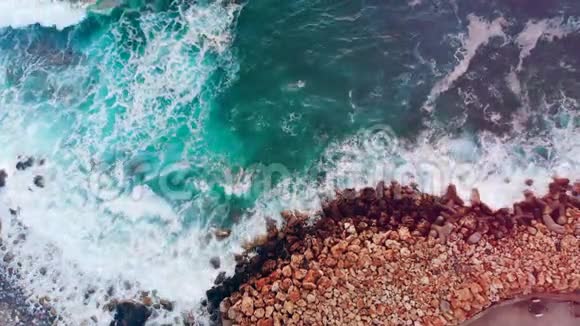 碧绿的海浪拍打着岩石海岸视频的预览图
