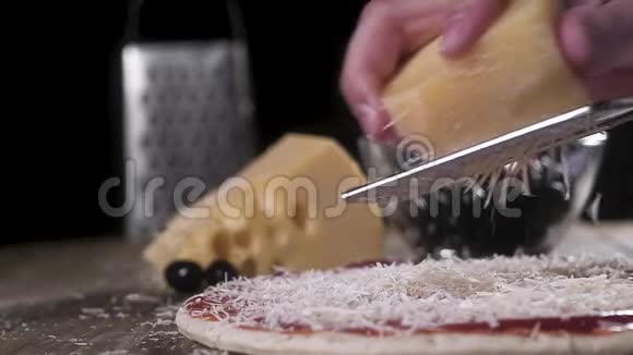 厨师用金属磨碎器在一个大比萨饼上用番茄酱摩擦奶酪意大利自制比萨饼的传统配方视频的预览图