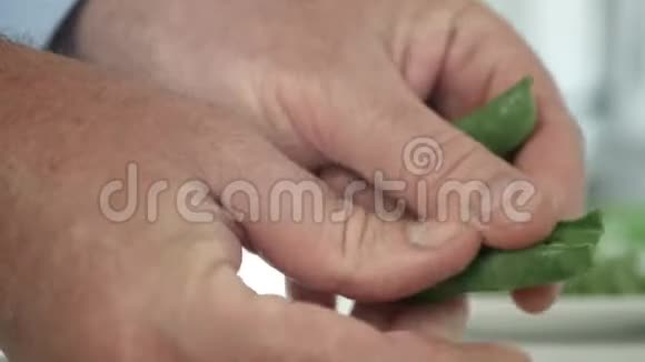 男士厨房选择及清洁新鲜绿色豌豆烹饪视频的预览图