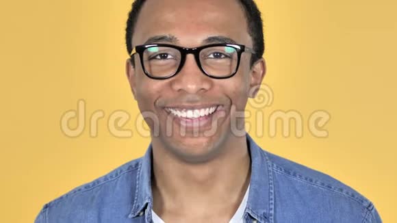黄色背景下微笑的非洲男人视频的预览图