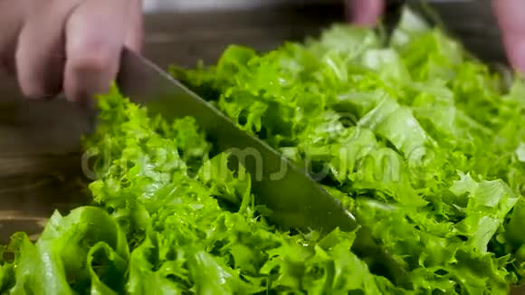 厨师切菜刀湿鲜绿色沙拉飞溅物和碎片散落在两侧慢动作视频的预览图