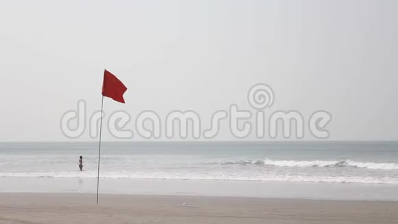 红旗迎风飘扬背景是沙滩和海中的一个女孩视频的预览图