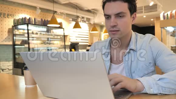 快乐的青年男子坐在咖啡馆里攫取贸易成果视频的预览图
