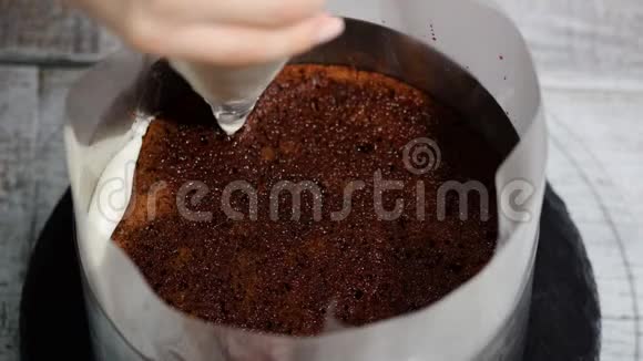 女人手在巧克力海绵蛋糕上撒鲜奶油视频的预览图