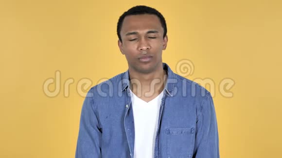 悲伤的非洲青年男子黄色背景视频的预览图