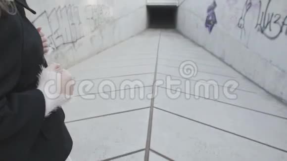 一个年轻女孩跑进了一条黑暗的混凝土隧道摄像机从后面跟着视频的预览图