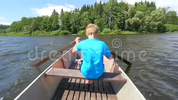 穿着救生衣的蓝色男孩腿上漂浮在船上发出刺耳的叫声坐金属船的年轻人在湖上航行视频的预览图
