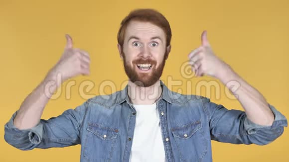 红发男子竖起大拇指黄色背景视频的预览图