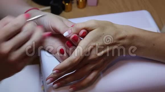 女性指甲画使用客户拇指钉上的刷子创建渐变近距离观察手和手指视频的预览图