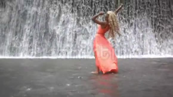 在大瀑布背景下摆姿势的年轻美女视频的预览图