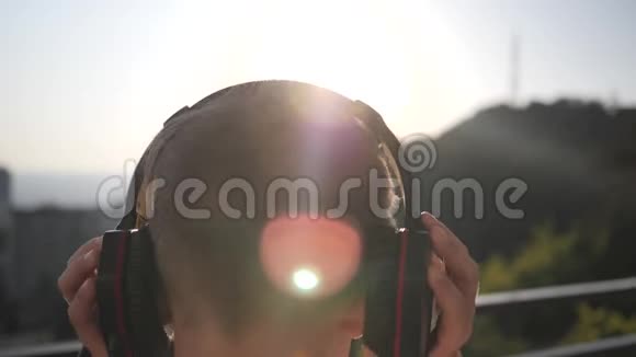 日落时分男孩在海边戴上耳机视频的预览图