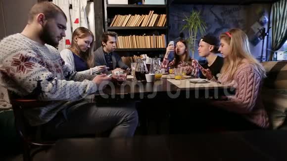 将军z在咖啡馆里使用智能手机的年轻朋友视频的预览图