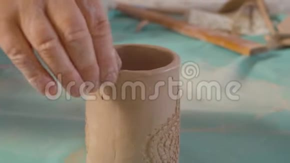 年长女性的双手将粘土杯的边缘对齐视频的预览图