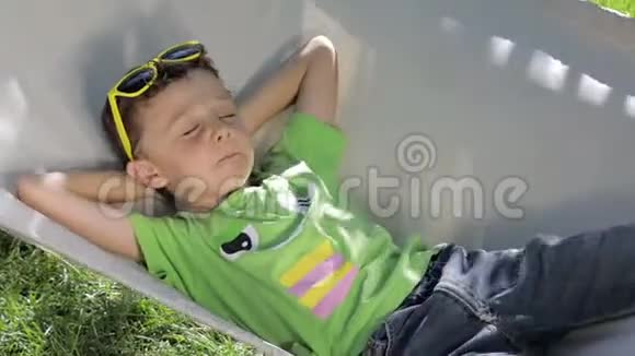 可爱的男孩躺在吊床上视频的预览图