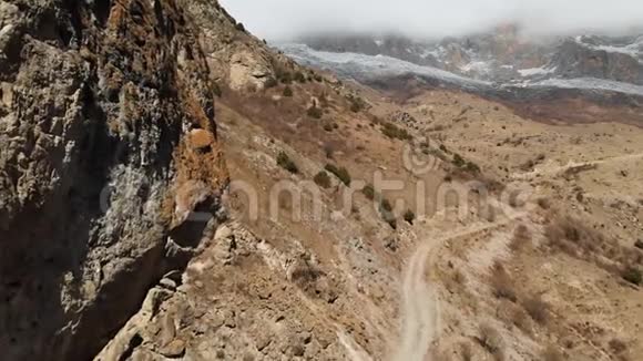 上巴尔卡里亚山脉峡谷的空中景色有一条土路和一片低云视频的预览图