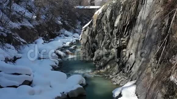 高山上有美丽的河流峭壁高耸积雪覆盖空中拍摄4k视频的预览图