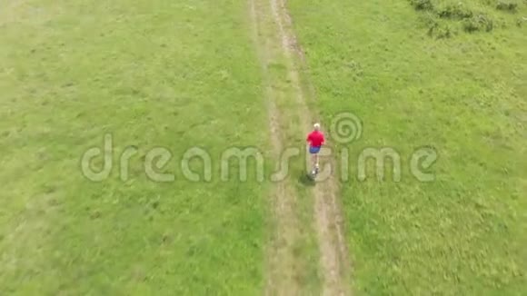 高级跑步者在草地上奔跑空中镜头视频的预览图