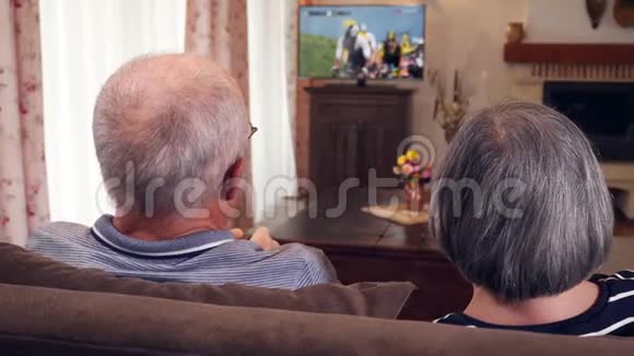 老两口坐在沙发上看电视视频的预览图