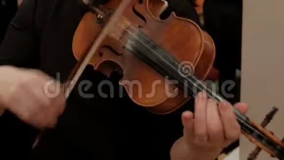 女人完成小提琴的演奏把乐器从肩膀上移开特写镜头右女性手有一个旋转视频的预览图
