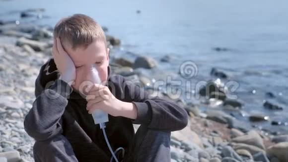 肖像儿童男孩使用雾化吸入面罩治疗哮喘海边视频的预览图