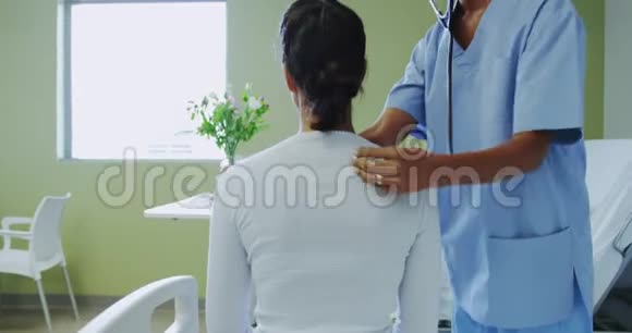 非裔美国女医生在医院病房检查女病人的侧视图视频的预览图