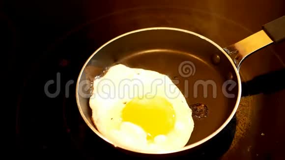 当蒸汽上升时将胡椒粉加入热煎锅中的新鲜鸡蛋中视频的预览图