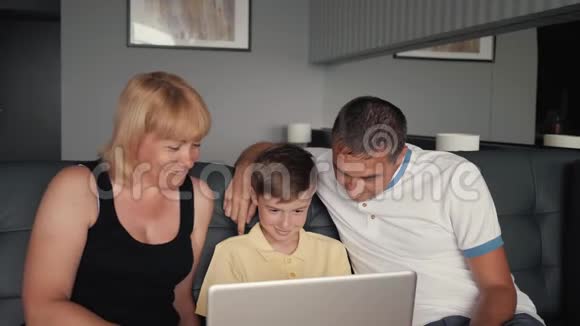 幸福的家庭坐在沙发上和亲戚在网上聊天为人民服务的现代技术视频的预览图