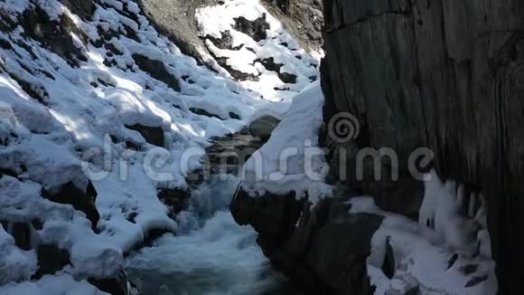 有多岩石的山和雪的美丽的泡沫的山河4k视频的预览图