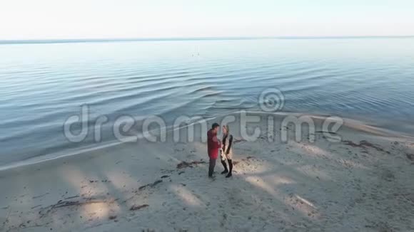 从顶部看到一对夫妇沿着沙质河岸散步夫妻在一起的时间关系视频的预览图