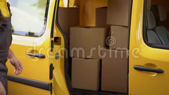 快递员把箱子放进黄色的货车里视频的预览图