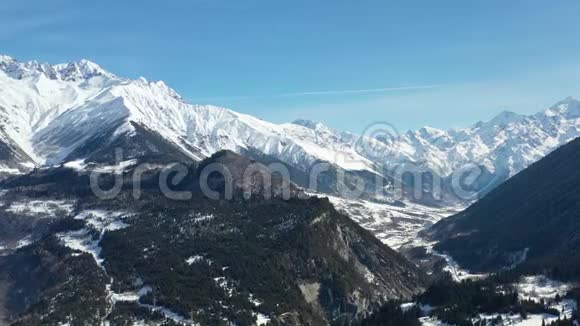 壮丽的阿尔卑斯山积雪覆盖山顶底部有树木4k视频的预览图