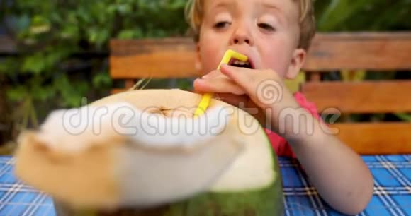 可爱的男孩喝椰子水视频的预览图